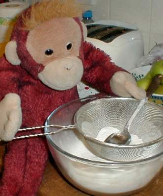 Big Mama Schweetheart orangutan sifts the flour into a bowl with the salt