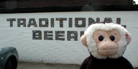 Mooch by the pub wall with sign built into it.