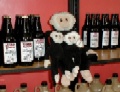 Mooch sits on a shelf surrounded by bottles!