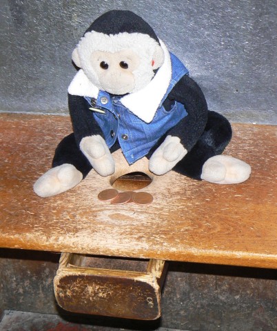 Mooch checks the old pennies will fit down the hole in the bench