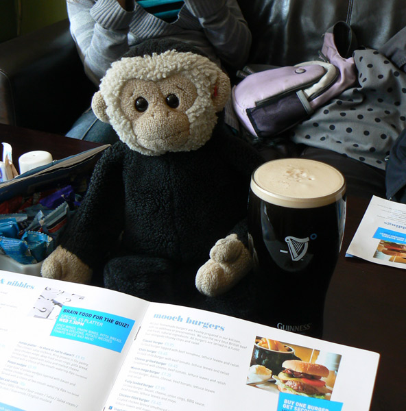 Mooch monkey with a Guiness and the menu at the mooch@76 cafe bar in Burgess Hill.