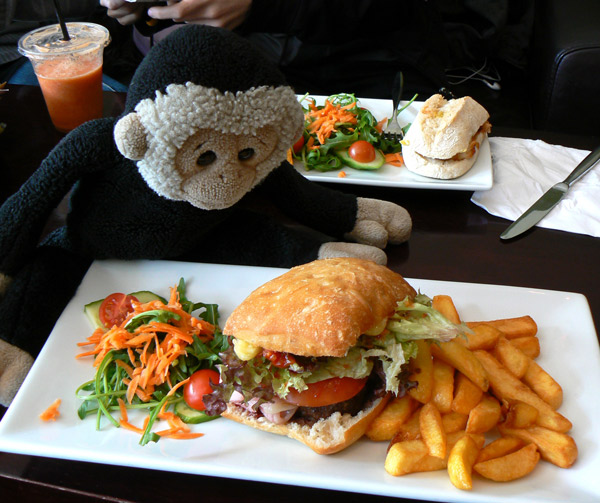 Mooch monkey looks at a burger, at the mooch@76 cafe bar in Burgess Hill.