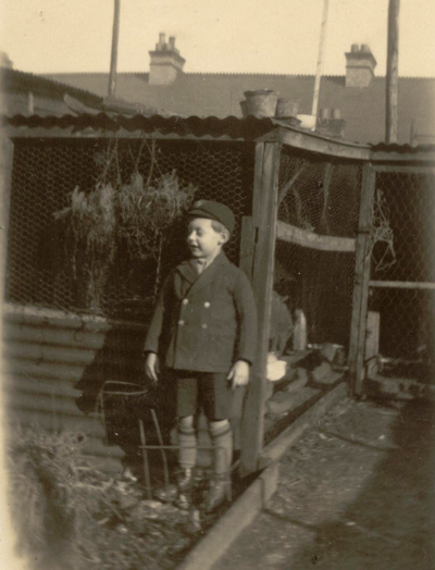 Bob in his school uniform beside the chicken run at 22 Lowestoft Road, Watford.