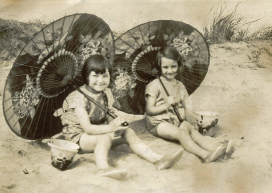 Una and Eileen on the Mablethorpe beach with paper parasols (c1929).