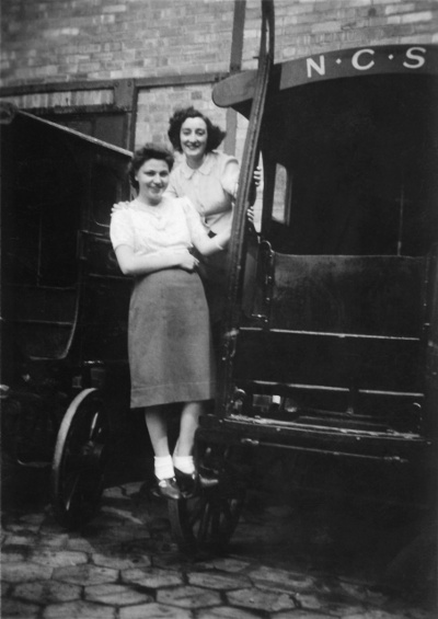 Una Briggs (Jones) and Gladys on a horse drawn van on the NCS Bakery forecourt. 1941.
