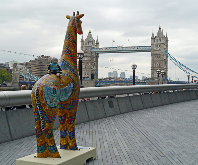 Mooch monkey on a giraffe in London