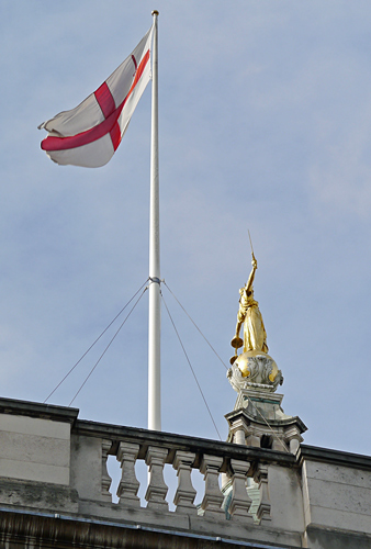 The City of London flag next to the Lady Justice statue