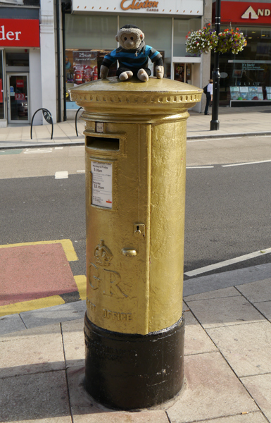 Mooch monkey sits on a gold letter box.