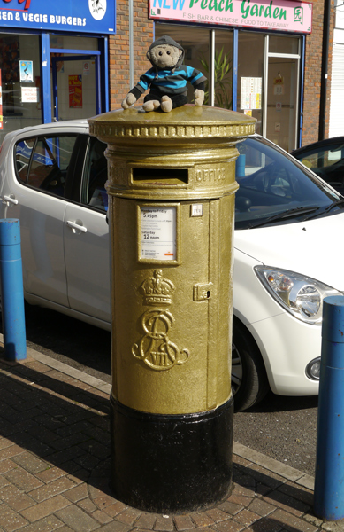 Mooch monkey sits on a gold letter box.