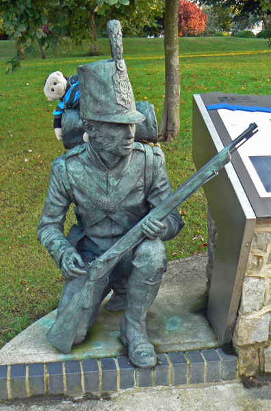 Mooch monkey sits on a military defender/rifleman statue in Hythe.