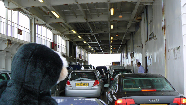 Mina monkey looking down the ferry's vehicle deck.