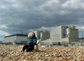 Mooch monkey sits on Dungeness beach in front of the power station .
