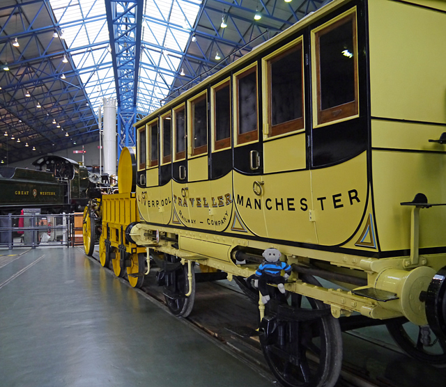 Mooch monkey sits on the carriage of a replica Rocket steam engine at the Railway Museum in York